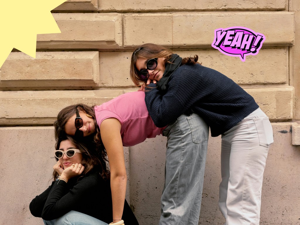 Trois jeunes femmes de la Gen Z avec des lunettes de soleil posant ensemble, illustrant l'amitié sur une application de chat sécurisée.