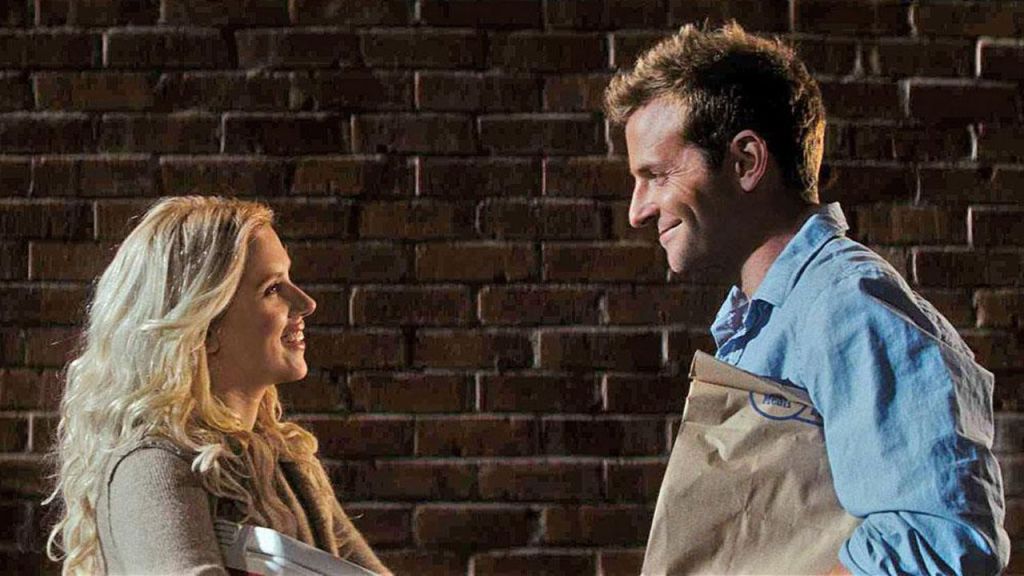 A woman and a man smiling at each other in a romantic movie scene from “He’s Just Not That Into You,” symbolizing emotional misreads.